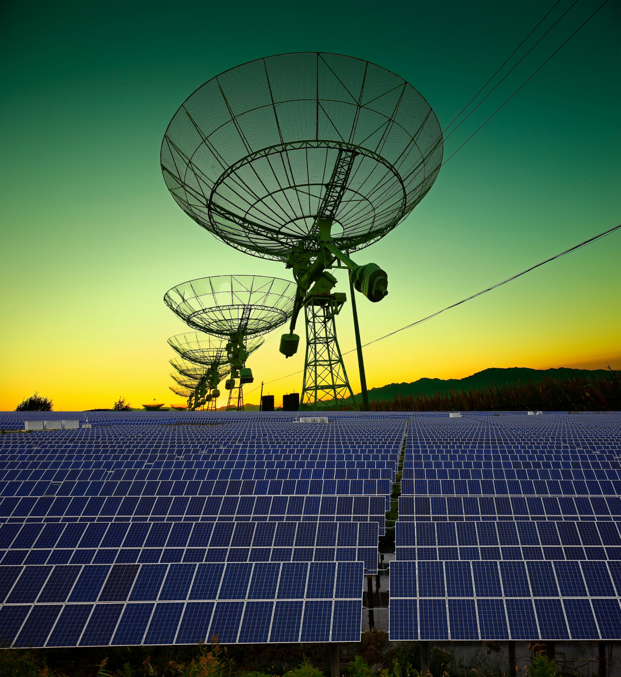 Photo of solar array with radio telescopes in background